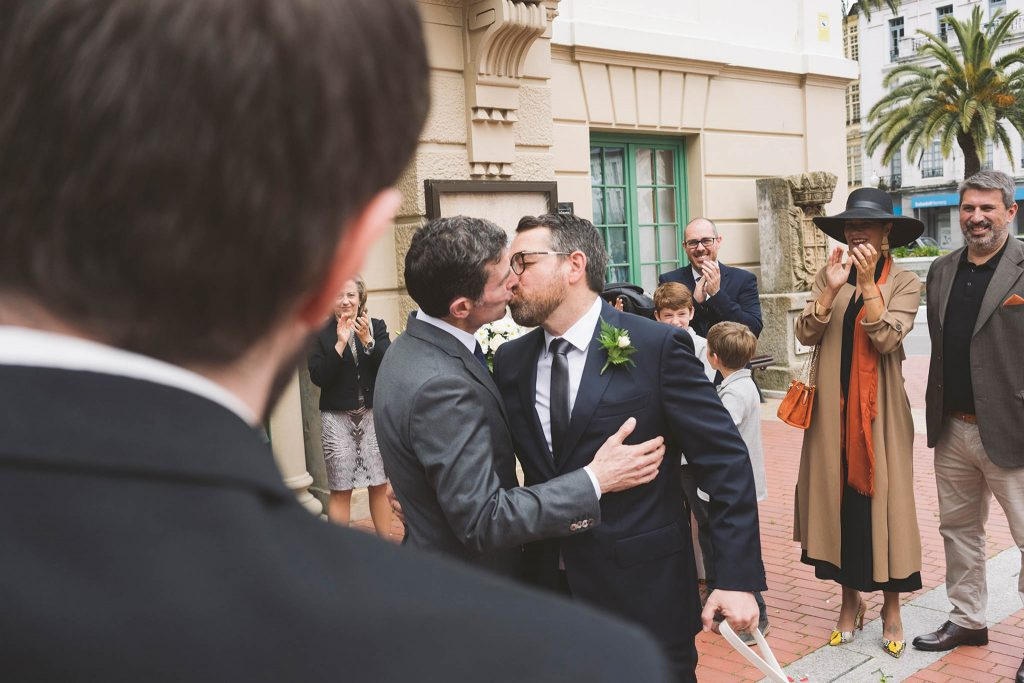 Un beso entre los novios tras la salida de la ceremonia.